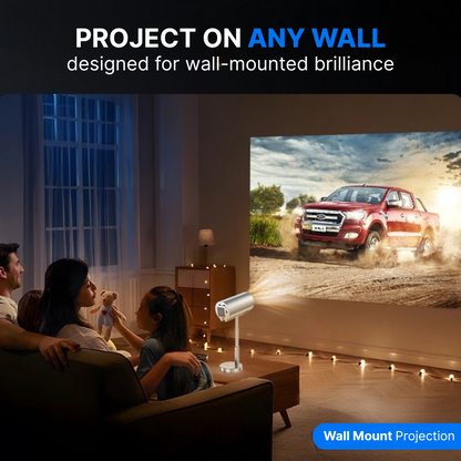 A family in a dim living room watching a wall projection of a red Ford Ranger pickup truck, illuminated by a silver projector on a coffee table and warm string lights on the floor, as a girl holds a teddy bear