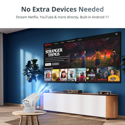 A white smart projector projecting Netflix's Stranger Things with colorful fireworks onto a large screen in a modern living room with a dark blue accent wall