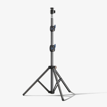 Product photography of a professional dark grey light stand featuring a telescopic center column, two vibrant blue quick-release adjustment levers, and a stable three-legged tripod base isolated on a clean white studio background