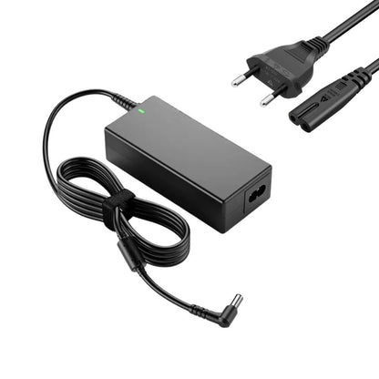 Black laptop power adapter kit on a white background featuring a rectangular power brick with a glowing green LED, a coiled DC cable with a right-angle tip and velcro strap, and a separate AC power cord with a European Type F plug and C7 connector