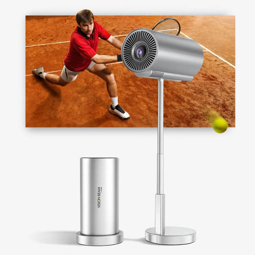 A silver cylindrical projector on an adjustable stand creates a projection of a male tennis player in a red shirt on a clay court hitting a vibrant yellow tennis ball, next to a matching silver device with the text VISION BEAM